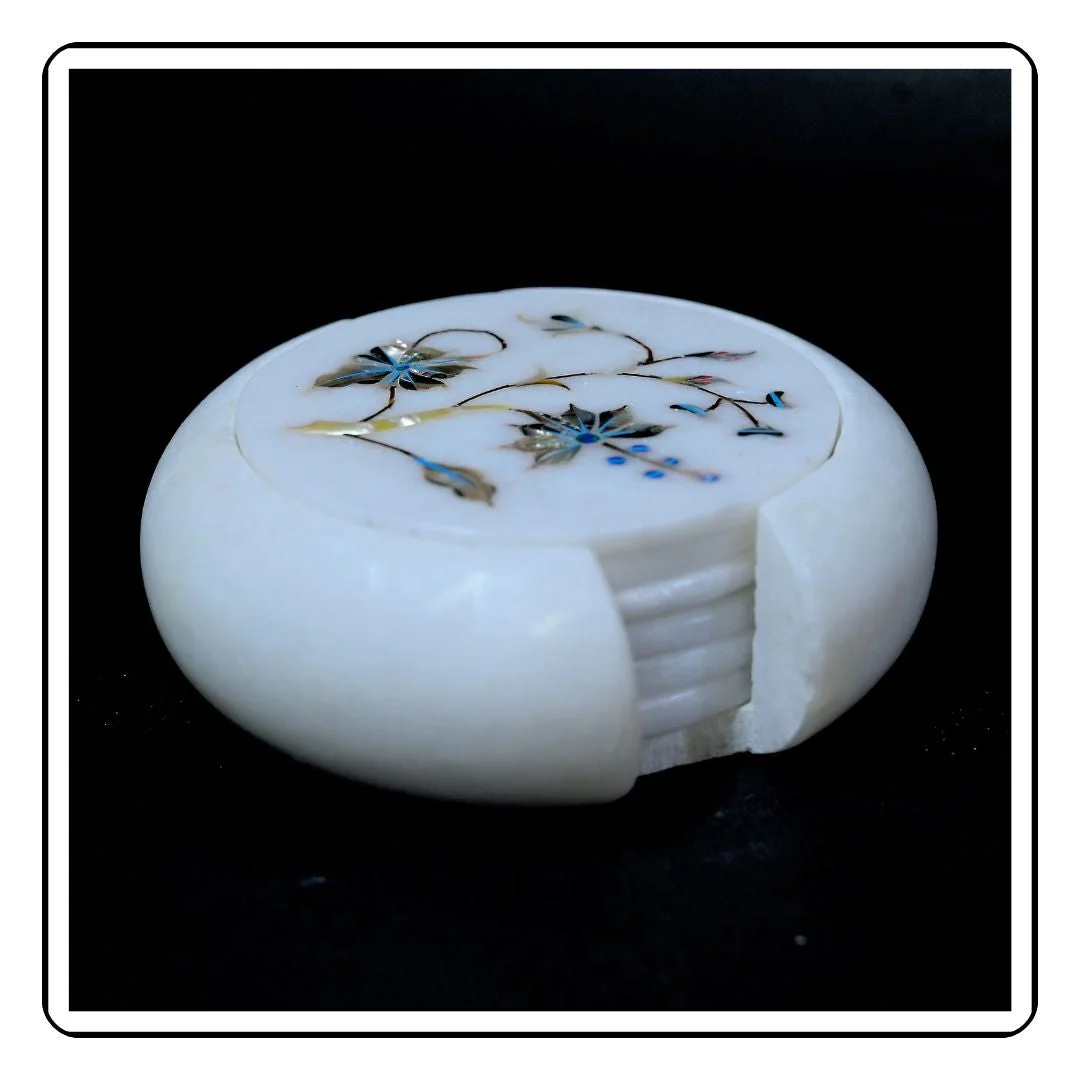 Side profile of a blue floral coaster made from polished white marble.
