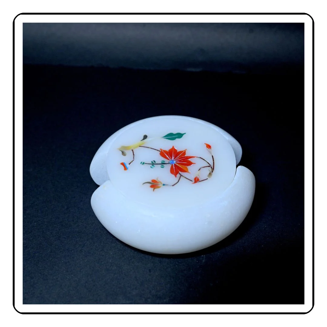 Elegant round marble coaster featuring red inlay work and white marble base.